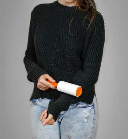 Girl cleans clothes sticky roller. Close up. Isolated.の写真素材