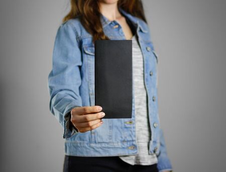 The girl in the blue denim shirt holds the black empty piece of paper. Ready for your design....