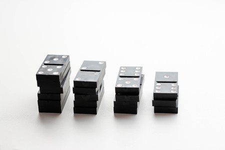 Domino lies the growing stacks. Isolated on a white background. Closeup.