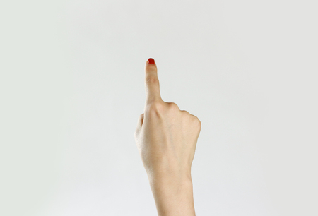 Female hand shows the direction. Isolated on gray background. Closeup.の写真素材