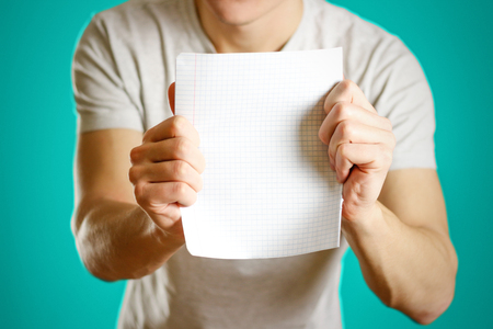 The guy shows empty clean notebook sheet in a cage.の写真素材