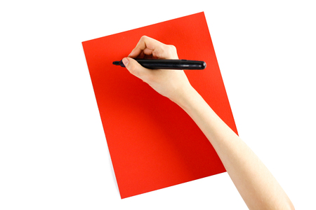 Hand holding black marker on red paper on a white background. Closeup.の写真素材