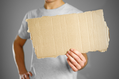 A young guy in a white t-shirt holding a piece of cardboard. Prepared for your text.の写真素材