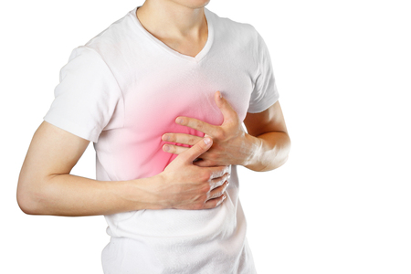 A man holds the Breasts. The pain in his chest. Heartburn. Stomach hurts. Sore point highlighted in red. Closeup. Isolated on white background.の写真素材