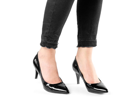 Girl in black shoes on high heels. Close up. Isolated on a white background.の写真素材