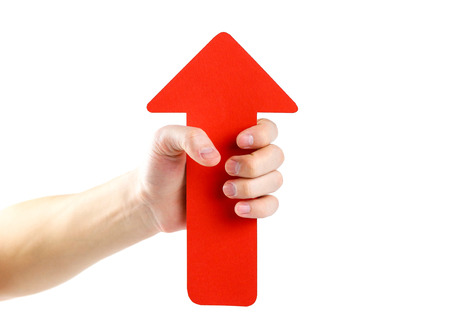 A man's hand holds a large red arrow. Close up. Isolated on a white background.の写真素材