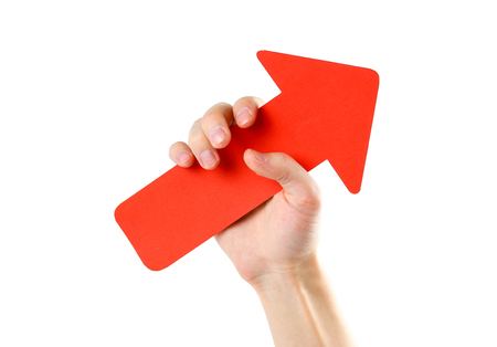 A man's hand holds a large red arrow. Close up. Isolated on a white background.の写真素材