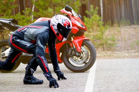 KRASNOYARSK, RUSSIA - April 27, 2018: Beautiful motorcyclist in full gear and helmet on a red and black Honda 2005 CBR 600 RR (PC37).のeditorial素材