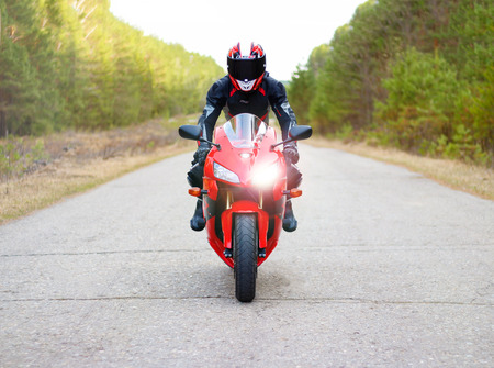 KRASNOYARSK, RUSSIA - April 21, 2018: Beautiful motorcyclist in full gear and helmet on a red and black Honda 2005 CBR 600 RR (PC37)のeditorial素材
