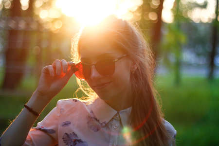 Portrait of a beautiful girl in a dress at sunset. Girl in the Sunny forest.