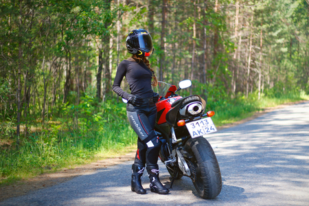 KRASNOYARSK, RUSSIA - June 23, 2018: Beautiful girl motorcyclist in full gear and helmet on a red and black Honda 2005 CBR 600 RR (PC37)のeditorial素材