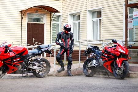KRASNOYARSK, RUSSIA - September 08, 2018: Beautiful motorcyclist in full gear and helmet and a two red and black Honda 2005 CBR 600 RR (PC37)のeditorial素材