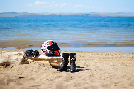 KRASNOYARSK, RUSSIA - August 9, 2018: Boots, gloves and helmet lying on the beach. Equipment on the beach by the seaのeditorial素材
