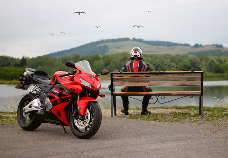 KRASNOYARSK, RUSSIA - July 17, 2018: Beautiful motorcyclist in full gear and helmet on a red and black Honda 2005 CBR 600 RR (PC37)のeditorial素材