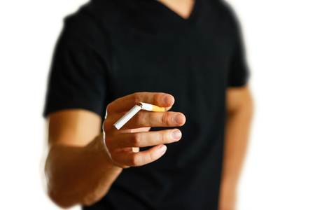 A man holds a broken cigarette in his hand. Close up. Isolated background.の写真素材