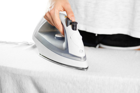 Girl Ironing t-shirt. Close up. Isolated background.の写真素材