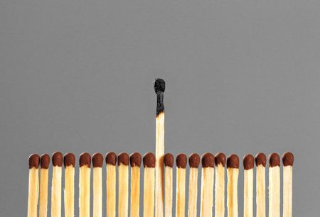Extinct matches. Burning match among others on isolated background. Difference and uniqueness concept.の写真素材
