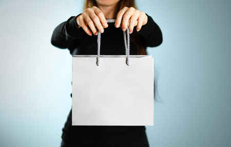 Girl holding a grey gift bag. Close up. Isolated background.の写真素材