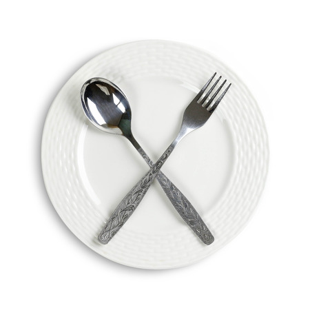 White ceramic plate and fork with spoon, top view. Close up. Isolated on white background.の写真素材