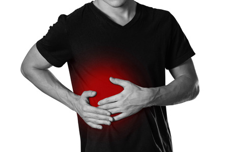 The man is holding his side. Pain in the liver. Cirrhosis. The hearth is highlighted in red. Close up. Isolated on white background.の写真素材