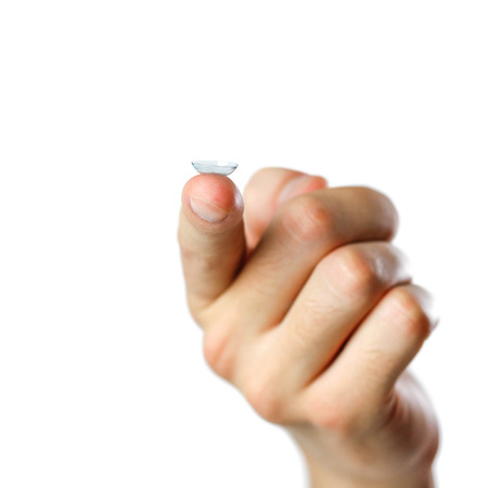 Lenses for the eyes on the finger. Close up. Isolated on white background.の写真素材