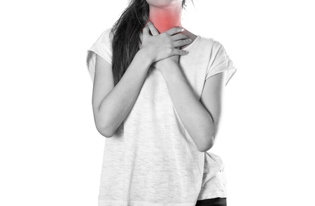 Girl holding her throat. Sore throat. Angina. Close up. Isolated on white background.の写真素材