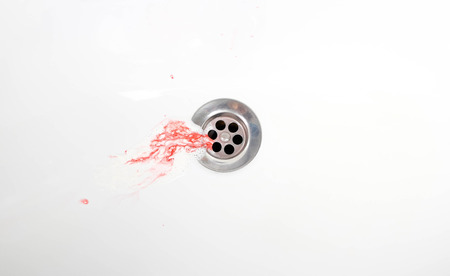 Toothpaste with blood in a ceramic sink. Bleeding gums. Close up.の写真素材