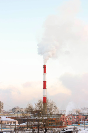 The smoke from the chimney of the boiler house. In the background of the city.の写真素材