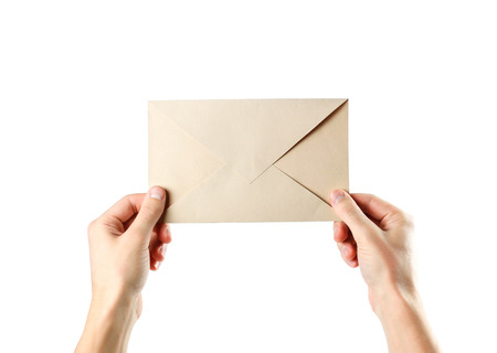 The hand holding the envelope. Close up. Isolated on white background.の写真素材