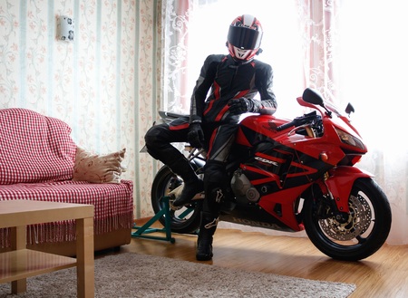 KRASNOYARSK, RUSSIA - December 21, 2018: Beautiful motorcyclist in full gear and helmet on a red and black Honda 2005 CBR 600 RR (PC37) in house.のeditorial素材