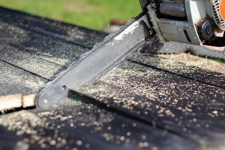 Man sawing boards with a chainsaw. Close up.の写真素材