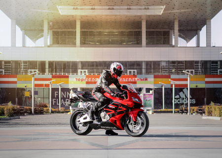 KRASNOYARSK, RUSSIA - September 24, 2019: Beautiful motorcyclist in full gear and helmet on a red and black Honda 2005 CBR 600 RR (PC37).のeditorial素材