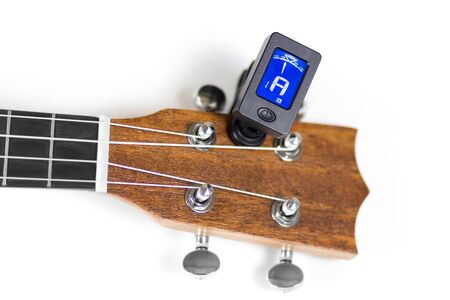 Tuning ukulele tuner. Close up. Isolated on white background.の写真素材