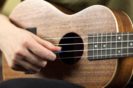 Girl playing the ukulele. Close up. Isolated on white background.の写真素材