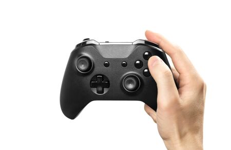 The hand holds a black gamepad for playing computer games. Isolated on a white background. Close up.の写真素材