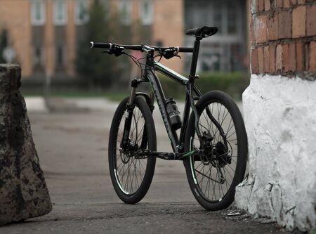 KRASNOYARSK, RUSSIA - April 29, 2020: Beautiful black and green mountain bike in the city. Evening....