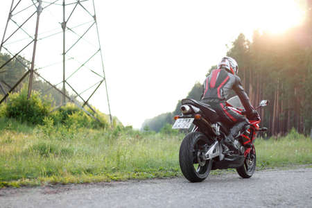 KRASNOYARSK, RUSSIA - June 27, 2019: Beautiful motorcyclist in full gear and helmet on a red and black Honda 2005 CBR 600 RR (PC37).のeditorial素材