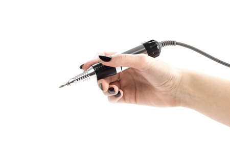 A female hand holds a nail cutter. Close up. Isolated on a white background.