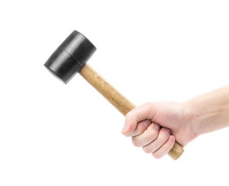 The hand holds a rubber mallet with a wooden handle. Ð¡lose up. Isolated on a white background.の写真素材
