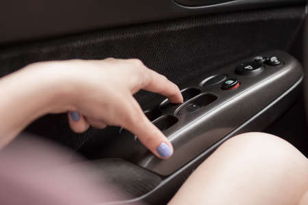The hand opens the electric windows of the car. Close up.の写真素材