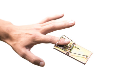 The hand was caught in a mousetrap. Close up. Isolated on a white background.の写真素材