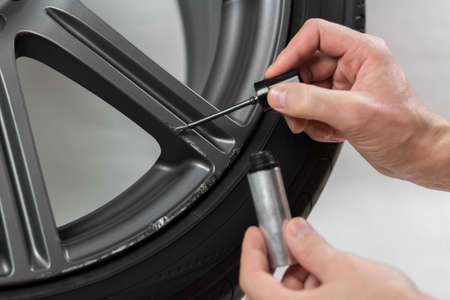 The hand painting the car wheel with a brush. close up. isolated on a white background.の写真素材