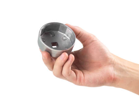 The hand holds the key for the oil filter. close up. isolated on a white background.