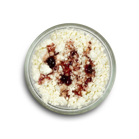 Cottage cheese with red jam in a glass plate. close up. isolated on a white background.の写真素材