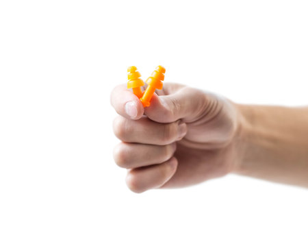 The hand holds bright earplugs on a white background.の写真素材