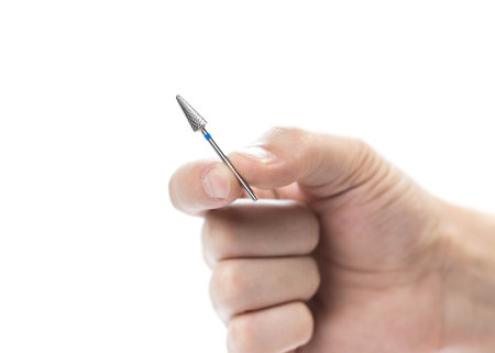 The hand holds a carbide cutter for manicure. closeup. isolated on a white background.の写真素材