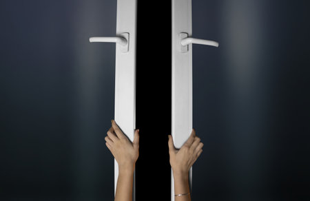 Hands opens the windows with a black background.の写真素材