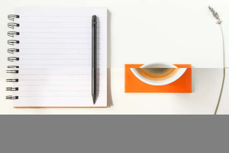 Notebook, pen and cup of coffee on white background, top viewの写真素材
