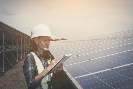 women engineer checking solar panel in routine operation  at solar power plantの写真素材
