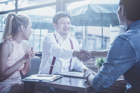 businessman signing contract and handshake after business negotiations to finally success at coffee cafeの写真素材